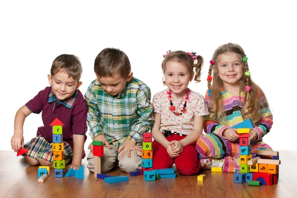 Čtyři děti si hrají na podlaze — Stock fotografie