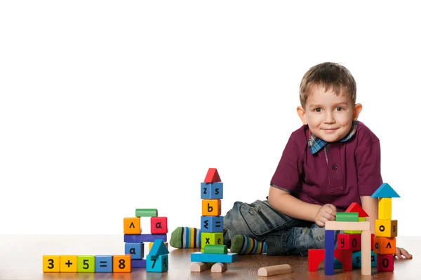 Niño pequeño en el suelo con juguetes —  Fotos de Stock