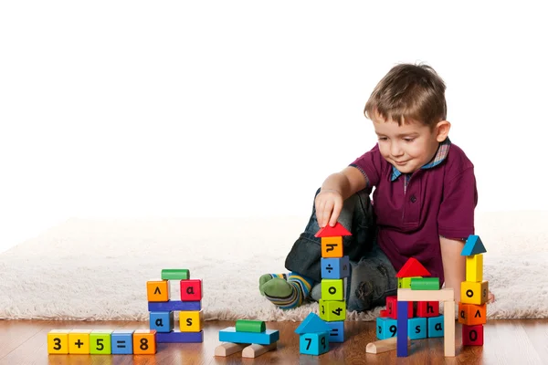 Menino bonito no chão com brinquedos — Fotografia de Stock