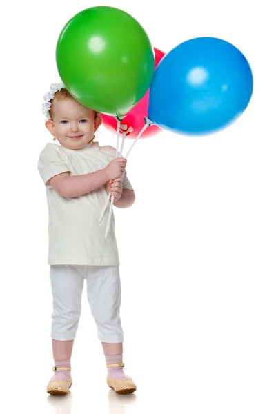 Усміхнена маленька дівчинка з повітряними кулями — стокове фото