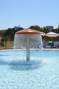 Mushroom-shaped fountain in the pool clipart