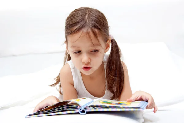 Милая девочка, читающая книгу — стоковое фото