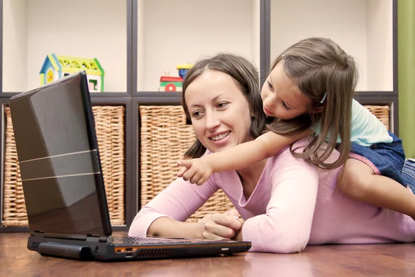 Madre y su hija delante de la computadora portátil Fotos de stock libres de derechos