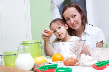 Mother and her daughter, bakeing in the kitchen clipart