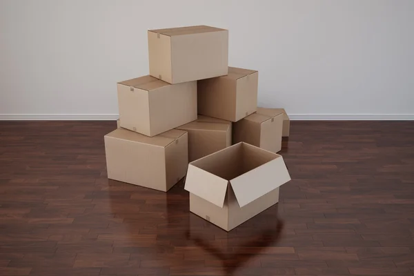 Cajas de cartón en habitación vacía con suelo oscuro —  Fotos de Stock