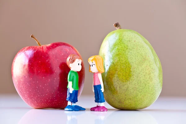 Ragazza e ragazzo che discutono di nutrizione sana (pera e mela ) — Foto Stock