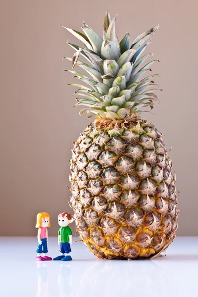 女の子と男の子の健康な栄養物 (パイナップルを議論します。) — ストック写真