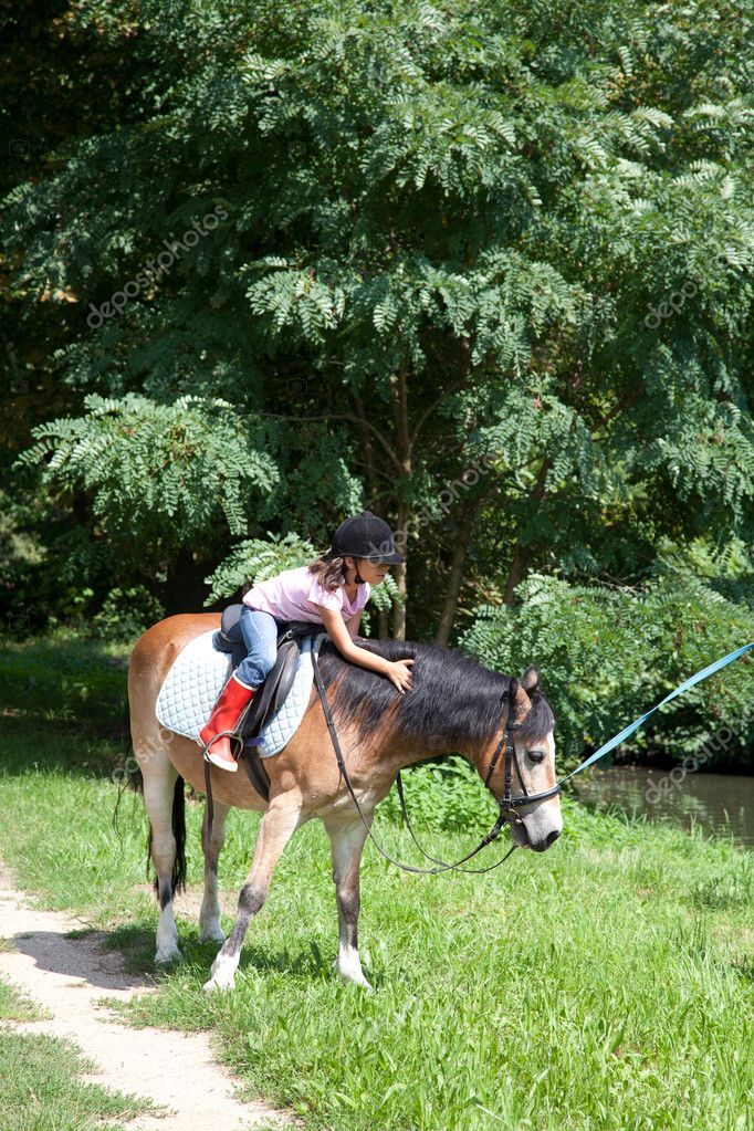 Little girl petting a horse while horseback riding — Stock Photo ...