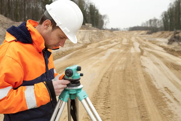 Construcción de carreteras, topógrafo de tierra mirando el equipo — Foto de Stock