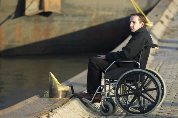 Инвалид на улице на инвалидной коляске — стоковое фото