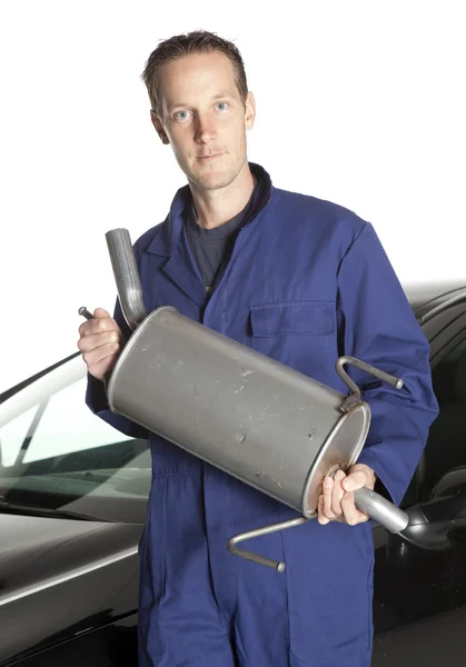 Mechanic looking at camera in studio with car — Stock Photo, Image