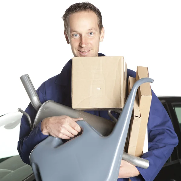 Mechanic looking at camera in studio with car — Stock Photo, Image
