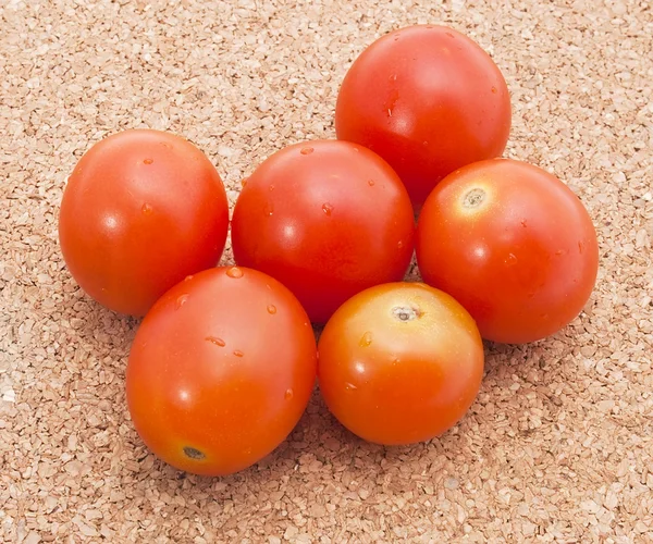Tomates cherry pequeños en el fondo de corcho — Foto de Stock