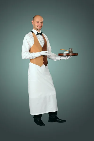 Официант в форме с кофеваркой и чашкой кофе . — стоковое фото