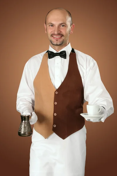 Ober in uniform met percolator en kopje koffie. — Stockfoto