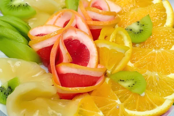 Rebanadas de naranja, pomelo y kiwi en un plato festivo —  Fotos de Stock