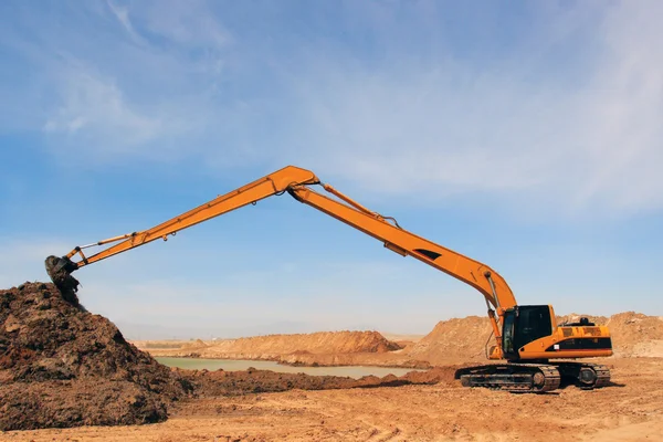 Orange excavator at construction site — Stock Photo, Image