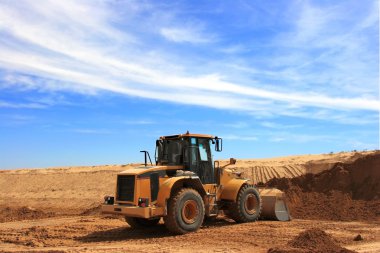 Orange excavator at construction site clipart