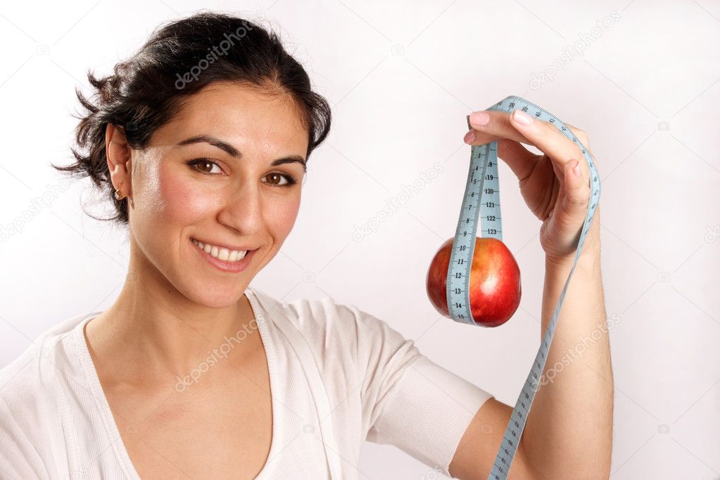 Smiling woman with red apple in tape measure