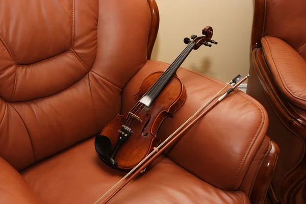 Violino em cadeira de couro — Fotografia de Stock