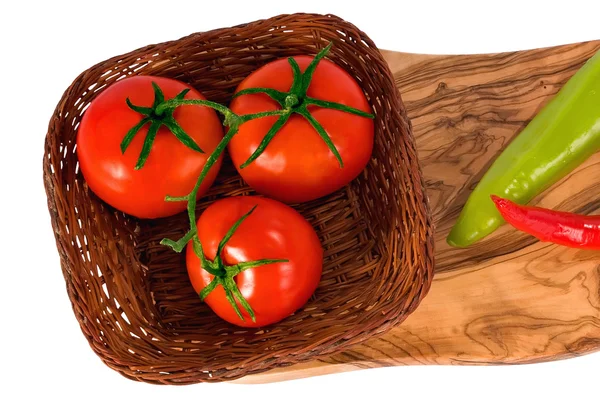 Three fresh red tomato on wicker plate — Stock Photo, Image