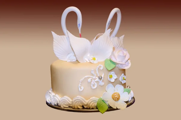 Svatební dort s květinami a postava labuť na přechodu — Stock fotografie