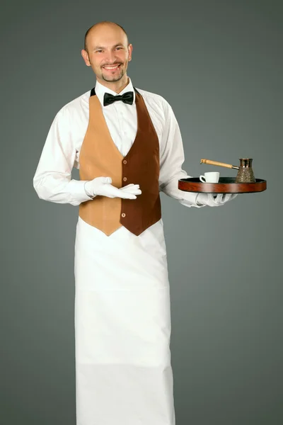 Waiter in uniform with percolator and cup of coffe. — Stock Photo, Image