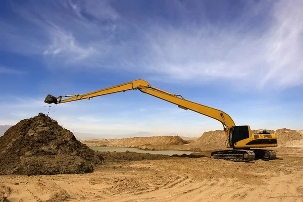 stock image Orange excavator at Construction irrigation canal in Desert