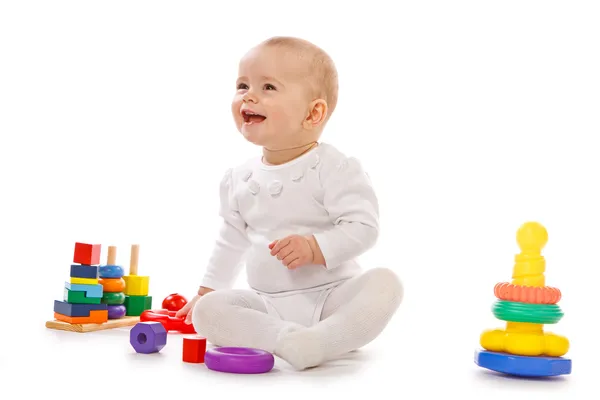 Маленький ребенок играть с игрушками на белом фоне — стоковое фото