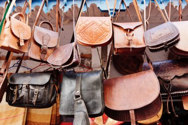Leather bags in a market in the street clipart