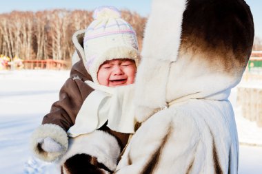 Mum with crying baby outside in cold clipart