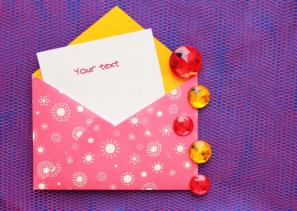 Roze envelop met witte cirkels en een notitie Stockafbeelding