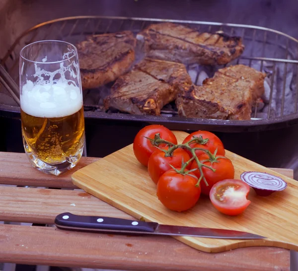Steaks on grill and beer — Stock Photo, Image