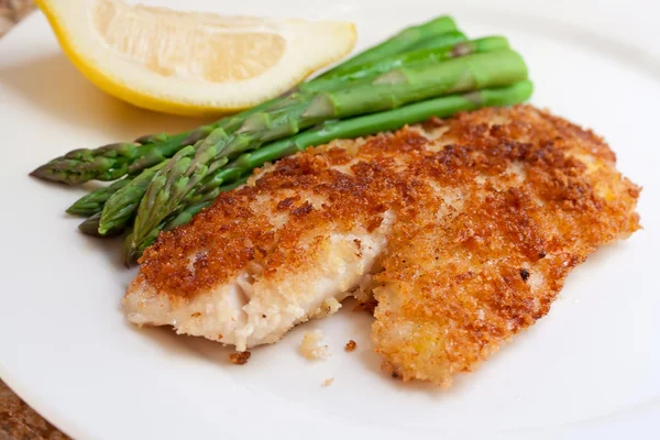 Fried breaded fish with asparagus and lemon — Stock Photo, Image