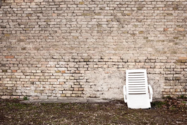 Éves fali és egy törött műanyag szék — Stock Fotó
