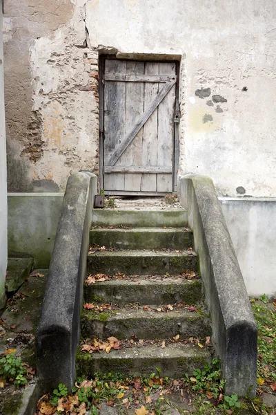 Лестница и деревянная дверь в стене — стоковое фото