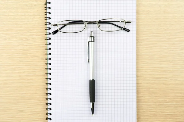 Glasses pen and notebook on a table — Stock Photo, Image