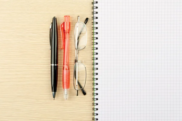 Two pens, galsses and notebook — Stock Photo, Image