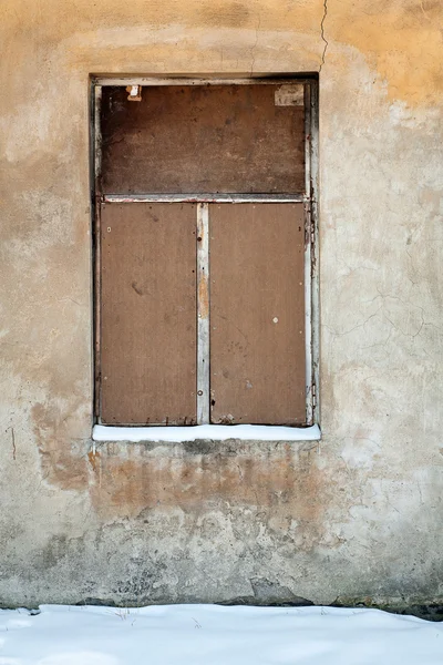 Gamla väggen med täckta fönster — Stockfoto