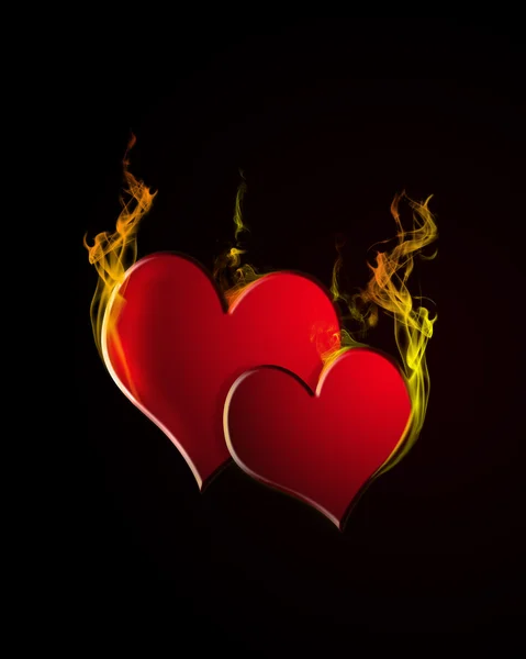 Дві палаючі серця на чорному тлі — стокове фото