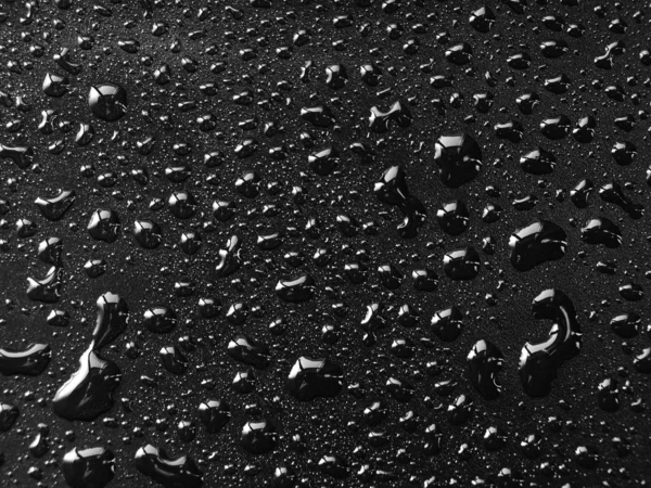 Water drops on black surface — Stock Photo, Image