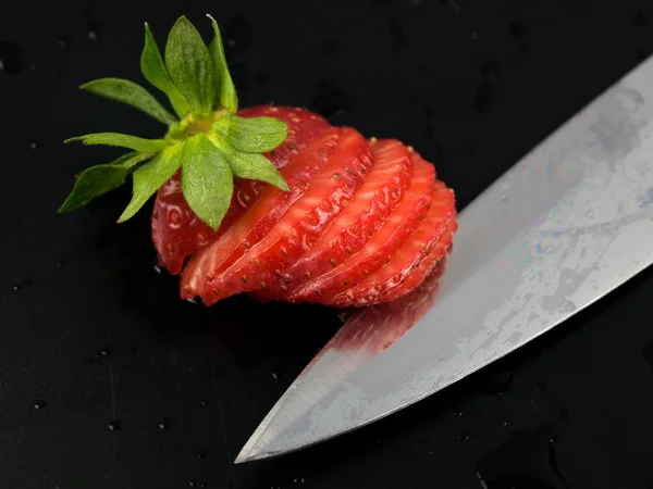 Gesneden srawberry met kife op zwart — Stockfoto