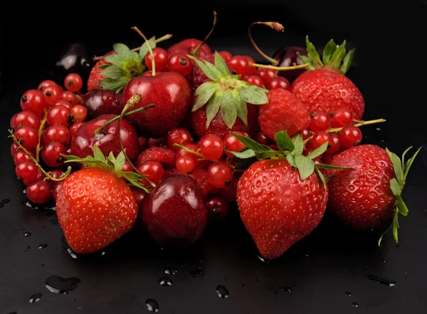 Свежие красные фрукты на черном фоне — стоковое фото