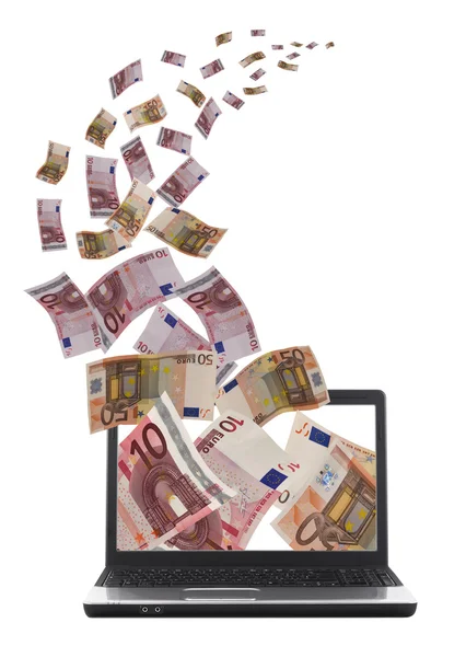 Lot af geld vliegen uit de buurt van laptop — Stockfoto