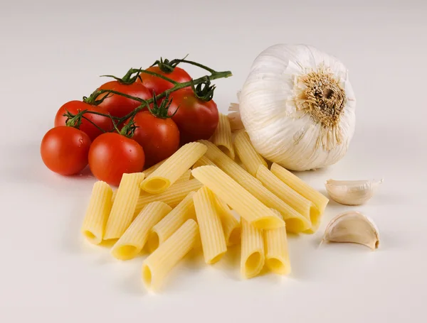 stock image Raw pasta with tomatoes and garlic