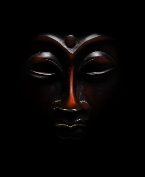 Braune Budda-Maske schwarz auf schwarzem Hintergrund — Stockfoto