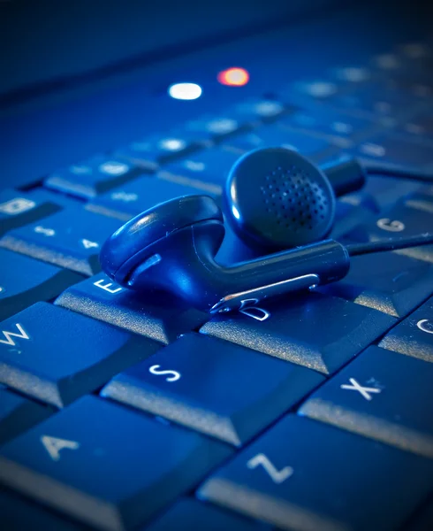 Kopfhörer auf Computer-Kajakbrett blauer Ton — Stockfoto