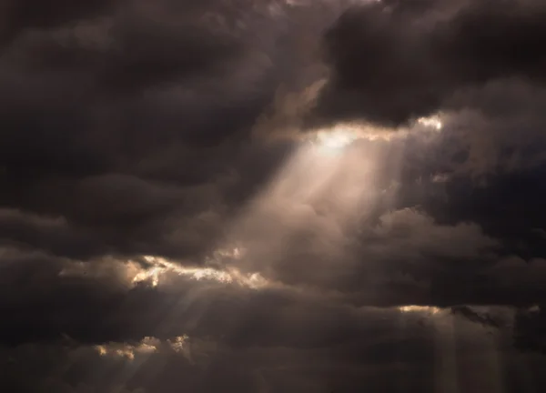 Sun ray trog zwarte stormachtige bewolkte hemel — Stockfoto