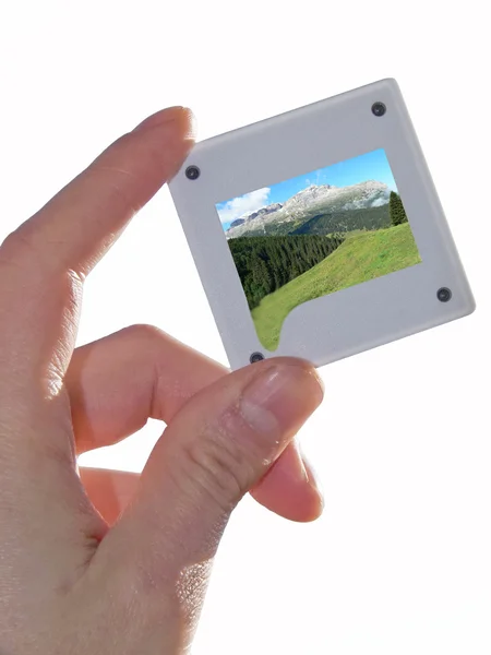 Mão mostra diapositivo com paisagem de montanha — Fotografia de Stock