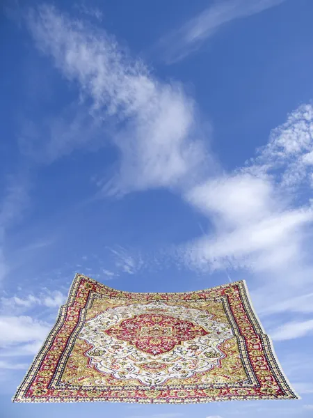 Flying carpet in a blue cloudy sky — Stock Photo, Image